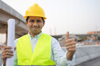© anut21ng Stock - construction male worker showing thumbs up and happy smiling at construction site