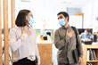 © Egoitz - Hispanic coworkers greeting with the hand on chest. Working in the office during Coronavirus pandemic concept.