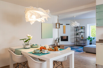 Elegant and romantic white table ready for breakfast with brioche, cups for coffee and fruits