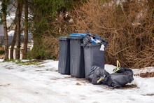 Garbage Bin Full Of Trash On White Snow In Residential Area In Winter.