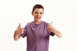 Happy teenaged disabled boy with cerebral palsy smiling at camera and showing thumbs up with both hands, posing isolated over white background