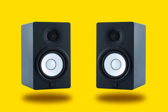 Wall Mural -  - Pair of professional high quality monitor speakers for sound recording, mixing, and mastering in studio in black wooden casing isolated on yellow background.