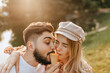 © Look! - Positive husband and wife biting orange ice cream on background of lake in park