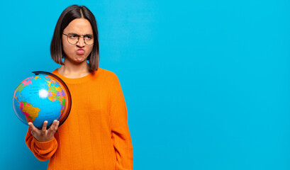 Wall Mural - young hispanic woman feeling sad, upset or angry and looking to the side with a negative attitude, frowning in disagreement