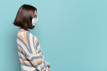 Wall Mural - young hispanic woman on profile view looking to copy space ahead, thinking, imagining or daydreaming