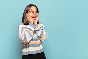 Sticker - young hispanic woman feeling happy, excited and surprised, looking to the side with both hands on face