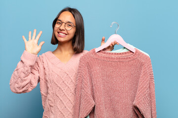 Canvas Print - young hispanic woman smiling and looking friendly, showing number five or fifth with hand forward, counting down