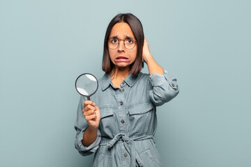 Wall Mural - young hispanic woman feeling stressed, worried, anxious or scared, with hands on head, panicking at mistake