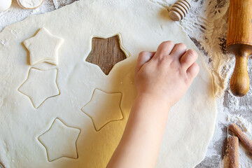 Wall Mural - A child makes a cookie. Selective focus.