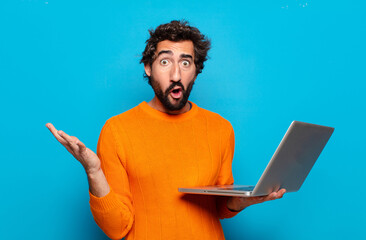 Poster - young bearded man holding a laptop. social media concept