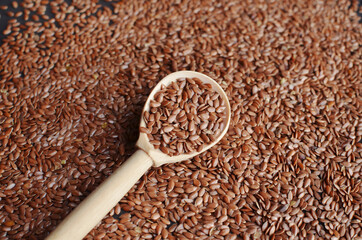 Dry flax seeds in wooden spoon.