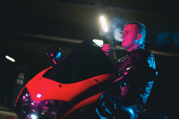 Wall Mural - A motor biker is smoking a cigarette close up.