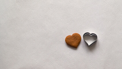 still life: heart shaped cookie and the baking dish on a light background