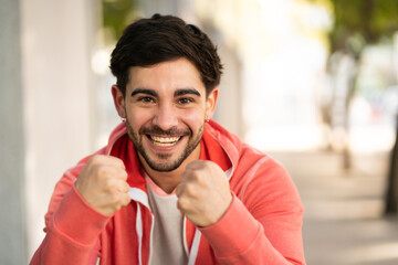 Young man celebrating victory outdoors.