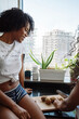 © sashapritchard - Two black female friends cutting fruit in the kitchen
