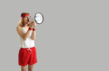 Funny Noisy Crazy Nerdy Man In Sports Shorts Yelling In Megaphone, Announcing Important Marketing Message, Advertising Workout Wear And Gym Equipment Sale, Standing On Grey Empty Space Background