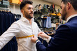 © Antonio Ovejero Diaz/Westend61 - Tailor in his menswear store taking customers measurements for suit