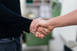 © Daniel Ingold/Westend61 - Male colleagues shaking hands in factory