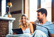 © klublu/Westend61 - Sweet couple on sofa with tablet