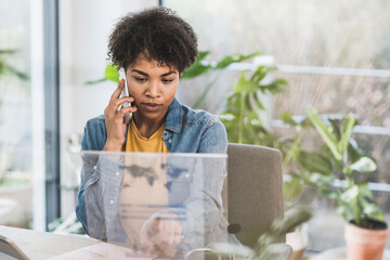 Woman talking on phone and using transparent display at home