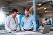 © Daniel Ingold/Westend61 - Two carpenters talking over documents in production hall