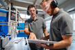 © Daniel Ingold/Westend61 - Two male carpenters talking over documents in production hall