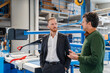 © Daniel Ingold/Westend61 - Two carpenters standing and talking in production hall
