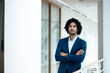 © Joseffson/Westend61 - Handsome young male professional standing with arms crossed contemplating in corridor of office