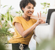© Uwe Umst√§tter/Westend61 - Smiling woman showing peace gesture on video call through digital tablet while sitting at home