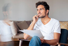 Thoughtful Man With Hand On Chin While Sitting At Home