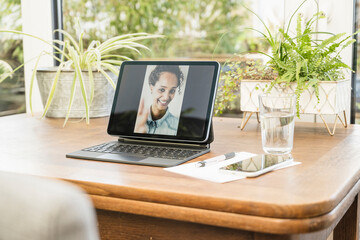 Smiling woman photograph on digital tablet at table in home