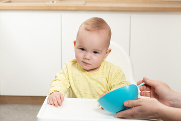 Wall Mural - Mother Feeding Baby Sitting In Chair