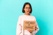 © Asier - Young hispanic mixed race woman holding an inspiring change message on cardboard screaming very angry and aggressive.