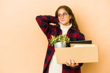 Wall Mural - Young caucasian woman moving holding a box isolated touching back of head, thinking and making a choice.