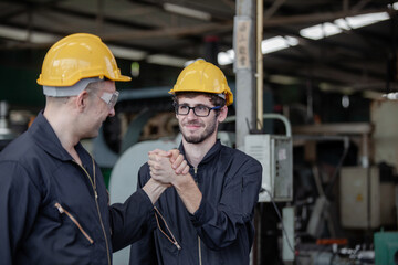 male workers and protective uniform shaking hands while working success teamwork collaboration. Two colleagues at a factory