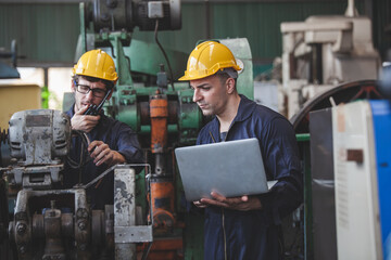 worker using digital laptop while supervising production at plant, copy space.  workers using machine equipment in factory