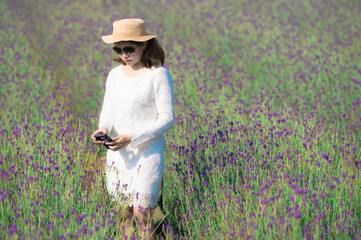 Wall Mural - Beautiful Asian woman wearing white dress in a lavender field blooming in the garden.