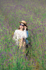 Wall Mural - Beautiful Asian woman wearing white dress in a lavender field blooming in the garden.