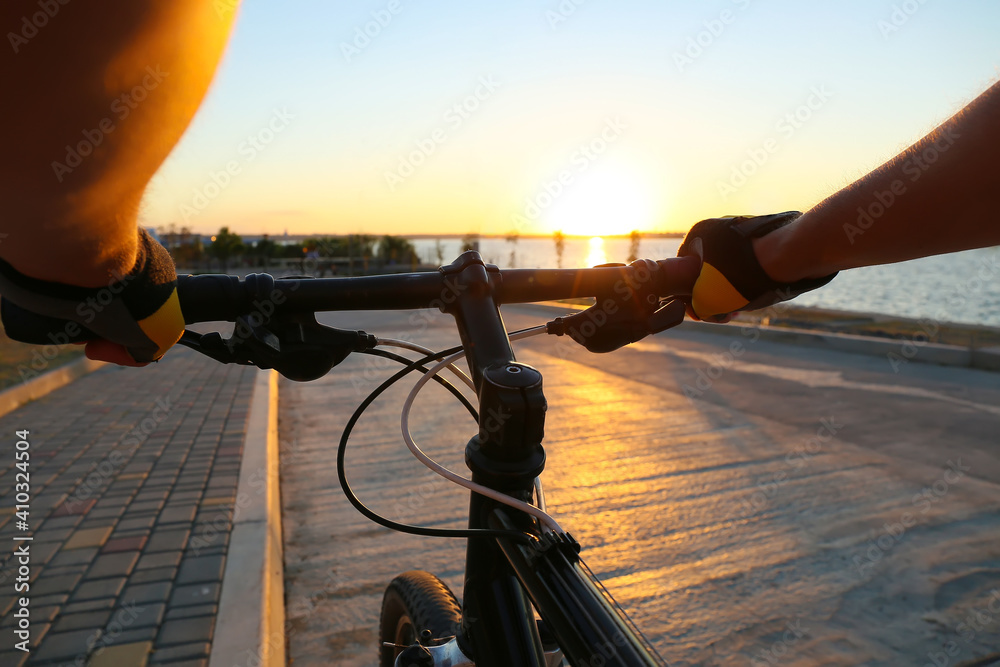 Male cyclist riding bicycle outdoors, closeup