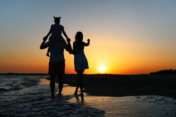 Canvas Print - Happy family on sea beach at sunset