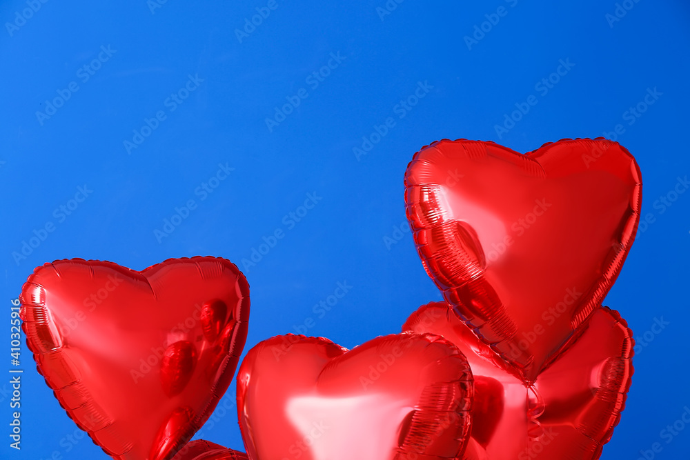 Heart shaped air balloons on color background