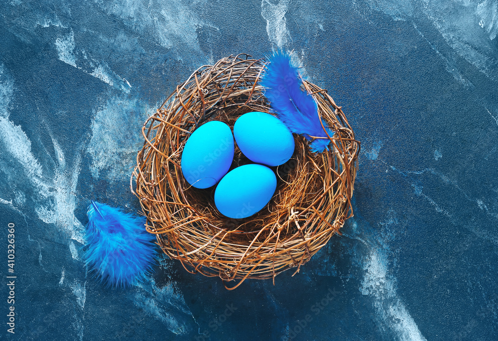 Nest with beautiful Easter eggs on color background