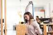 © Egoitz - Healthy lifestyle in the workplace concept. Woman with backache or back pain  stretching with a pilates rubber band in the office.