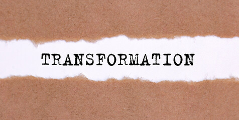 Poster - The text TRANSFORMATION appearing behind torn brown paper.