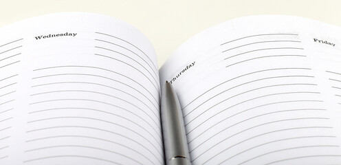 Poster - silver pen on open business agenda on white background