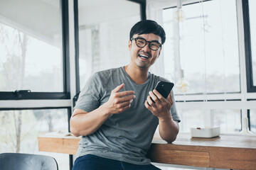 asian man work using cell phone hand holding mobile texting message contact us.chatting,search internet information in office.technology device communication connecting