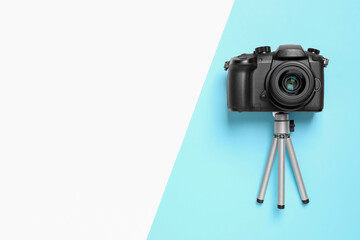 Wall Mural - modern camera and mini tripod on color background, flat lay with space for text. video production eq