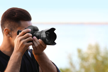 Sticker - Photographer taking picture with professional camera near river