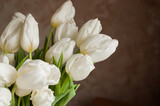 Fototapeta Kwiaty - A bouquet of white tulips in a glass vase at home.