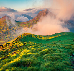 Fantastic summer sunrise on Carpathian mountains, Ukraine, Europe. First sunlight glowing mountains peaks. Foggy outdoor scene of countryside.  Beauty of nature concept background.